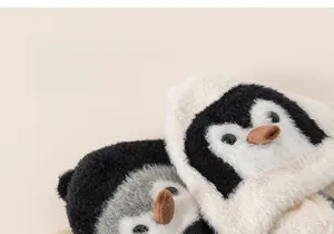 Close-up of plush penguin hat detail showing soft black and white faux fur texture
