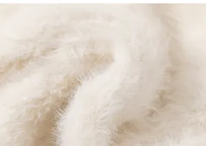 Close-up of fluffy off-white faux mink fur fabric texture for warm kids beanies