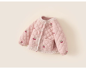 Détail d'une veste matelassée rose pour fille avec broderies cerises et nœuds décoratifs