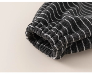 Gros plan sur les poignets élastiques du pantalon rayé gris foncé pour enfants