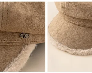 Detailed macro view of the brown suede beret featuring the bronze R-letter and plush brim