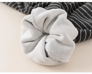 Détail du pantalon rayé pour enfant montrant la doublure polaire blanche pour l'hiver