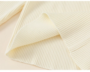 Close-up of cream ribbed knit fabric showing soft texture and vertical patterns