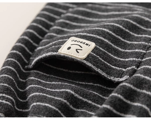 Gros plan d'un pantalon rayé en polaire pour enfant avec écusson sourire mignon