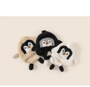 Detailed view of plush penguin earflap hats for kids in khaki, black, and white colors
