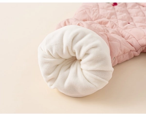 Détail du poignet d'un manteau matelassé pour fille avec doublure polaire et broderie cerise