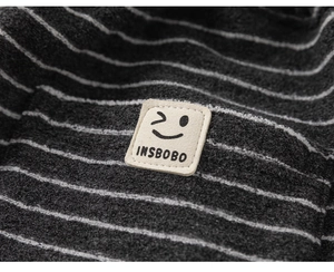 Gros plan sur la texture rayée et l'écusson de la marque sur ce pantalon pour enfant