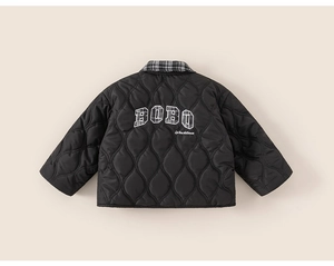 Detail view of children's black quilted jacket featuring BOBO embroidery and checkered collar
