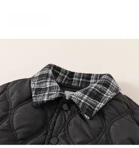 Close-up of quilted black jacket with checkered collar and BOD embroidery detail