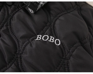 Detailed view of black quilted jacket featuring white BOBO embroidery and checkered collar