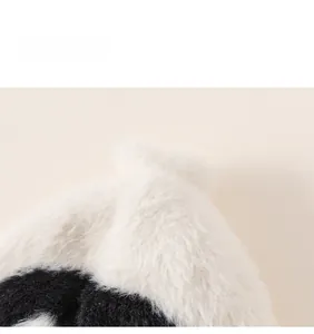 Close-up detail of soft black and white plush faux fur fabric on a children's winter hat