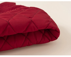 Detail of red diamond quilted fabric with satin finish for girls winter dress