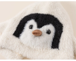 Close-up of a plush white penguin winter hat with detailed embroidery and 3D beak
