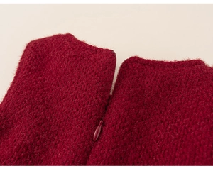 Detail shot of invisible zipper on a red knitted winter dress for toddler girls