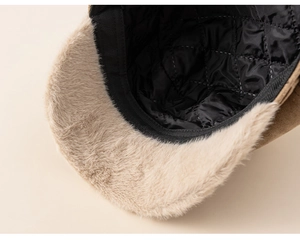 Macro detail showing black quilted inner lining and soft beige faux fur trim of the kids beret