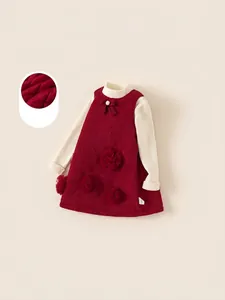 Winter girls' outfit with a beige turtleneck sweater and a padded red floral dress