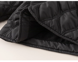Detailed close-up of children's black quilted jacket with warm fleece lining and stitching