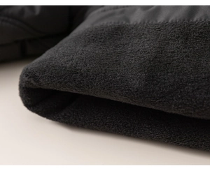 Close-up of black fleece winter jacket detail showing thick warm fabric and soft texture