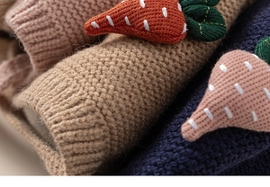 Close-up of knit hats for kids featuring 3D strawberry and carrot wool decorations