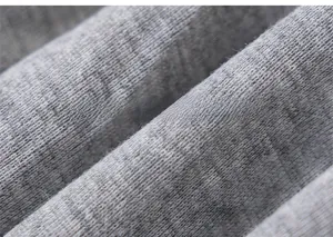 Macro detail of soft grey heather knit fabric with textured mixed-color wool fibers