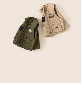 Detailed flat lay of boys warm utility vests featuring cargo pockets and quilted lining