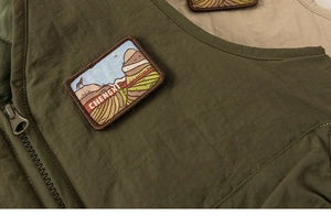 Close-up of durable ripstop fabric and embroidered mountain patch on boys outdoor vest