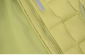 Detail of lime green quilted down jacket with zipper closure and reflective safety strip