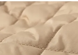 Detailed macro view of khaki quilted fabric with diamond stitching and satin texture