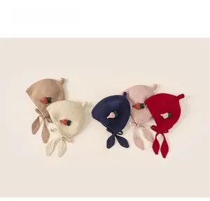 Detail of baby knitted earflap hats in five colors with carrot patches and bunny ties