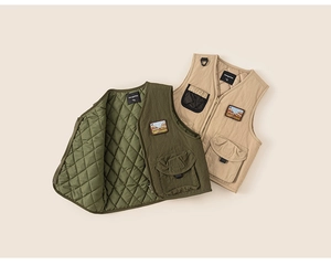 Detail of quilted utility vests with V-neck zip and embroidered patches for kids
