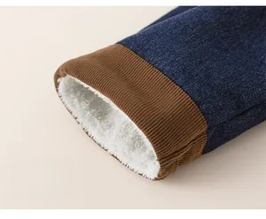 Detailed macro view of boys winter denim trousers showing thick fleece lining and ribbed cuffs