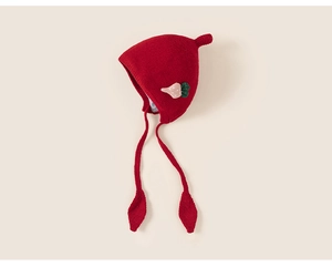 Detail of red knit baby hat with cute strawberry patch and green leaf tie accents