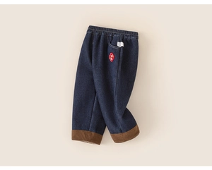 Detail of dark blue kids denim pants featuring elastic waist and brown corduroy cuffs
