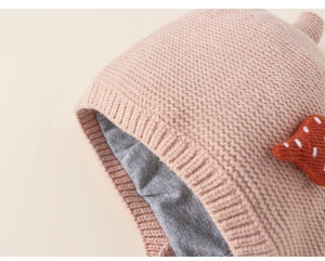Detail of pink knitted baby hat showing soft grey inner lining and fine stitch texture