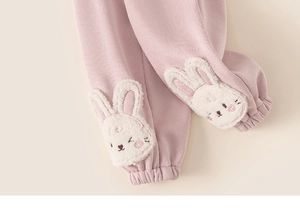 Detailed view of pink fleece trousers featuring cute plush rabbit embroidery for girls