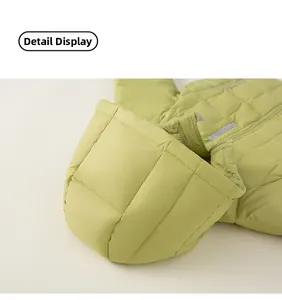 Detail of light green hooded down jacket showing quilted square pattern and zipper