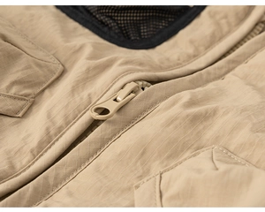 Detailed macro view of khaki ripstop fabric and smooth resin zipper on kids outdoor vest
