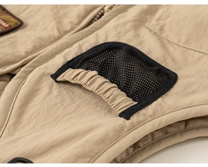 Detail of khaki ripstop fabric vest with black mesh pocket and elastic trim design