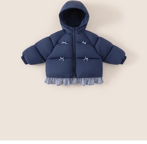Detail of navy quilted hooded coat for girls with white cross-stitch and plaid ruffle hem