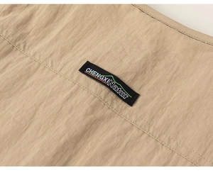 Macro detail of khaki ripstop fabric with woven mountain label and double stitching