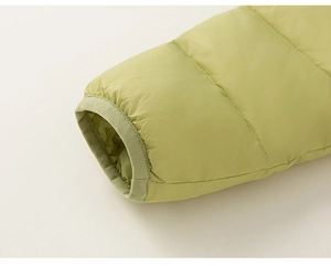 Detail of green down jacket sleeve with elastic cuff and horizontal quilting finish