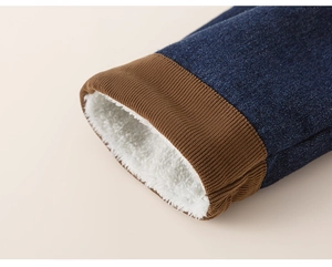 Detail of warm white fleece lining and navy denim fabric on winter boy's trousers