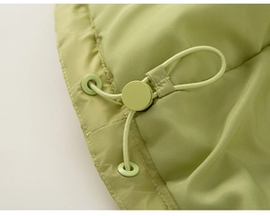 Detail of adjustable hem with elastic drawstring and toggle on green down jacket