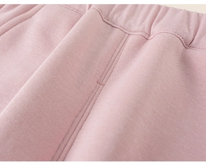 Close-up of pink children's jogger pants showing elastic waistband and soft knit fabric texture
