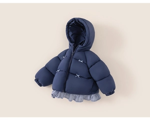 Close-up of navy padded kid coat with bow embroidery and checkered ruffle hem detail
