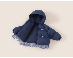 Detail of navy blue quilted puffer jacket for girls with plaid ruffle hem and embroidery