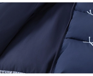 Detail of dark blue quilted kid coat with zipper and light blue ribbon bow decoration