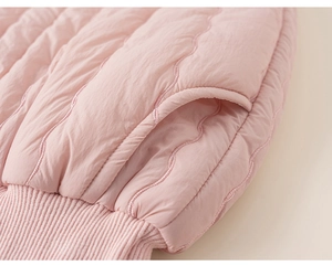 Vue détaillée du tissu matelassé rose avec coutures ondulées et revers élastique côtelé