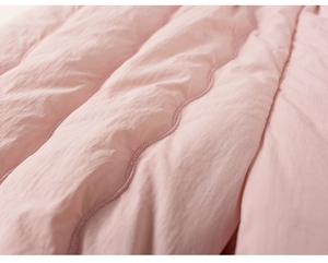 Détail du tissu matelassé rose doux avec coutures ondulées et texture moelleuse pour enfants