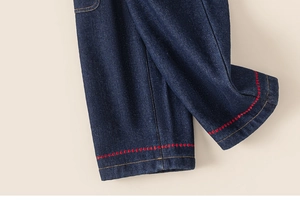 Detail of dark blue denim hem with red decorative stitching and thick cotton texture